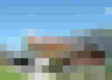 Traditioneller Alpengasthof mit Balkonblumen vor Bergpanorama in den Hohen Tauern